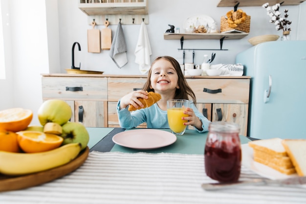 Bezpłatne zdjęcie mała dziewczynka ma jej śniadanie