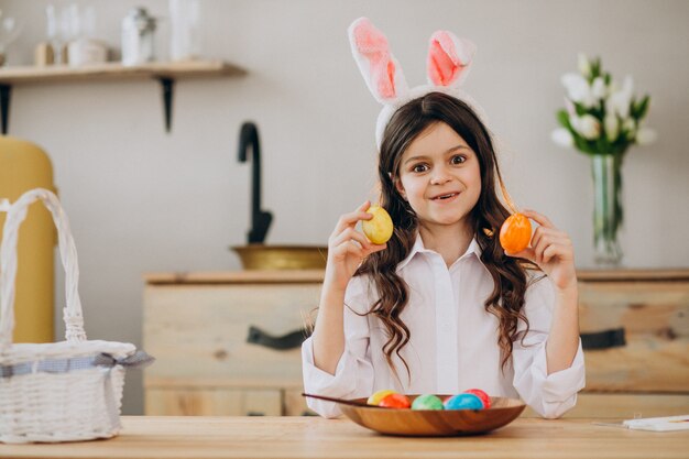 Mała dziewczynka maluje jajka dla Easter