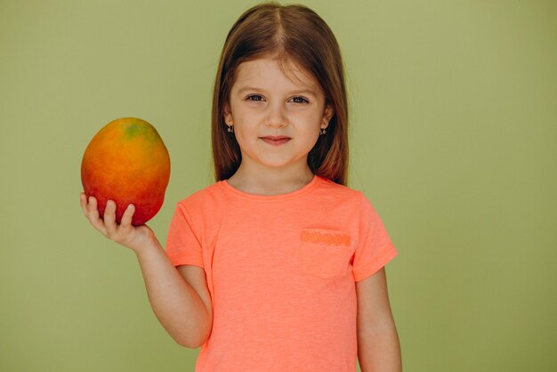 Mała dziewczynka na białym tle gospodarstwa mango