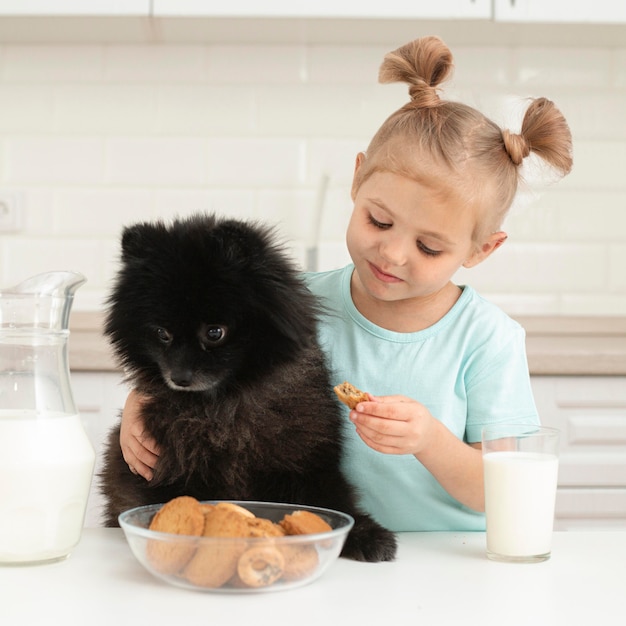 Mała dziewczynka pije mleko z psem