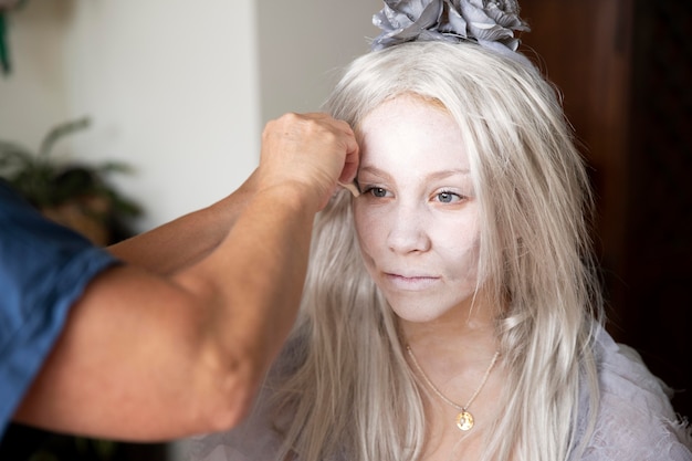 Mała dziewczynka przygotowuje się do Halloween w kostiumie ducha