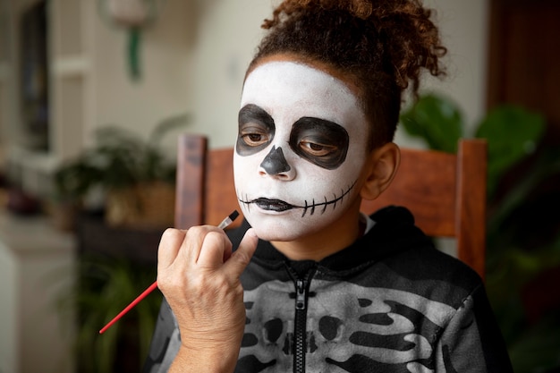 Mała dziewczynka przygotowuje się do Halloween w kostiumie szkieletu