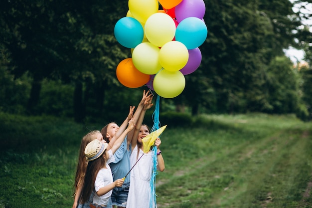 Bezpłatne zdjęcie mała dziewczynka przyjaciele z balonami w lesie