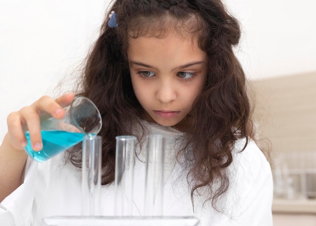 Mała dziewczynka robi eksperyment naukowy w szkole
