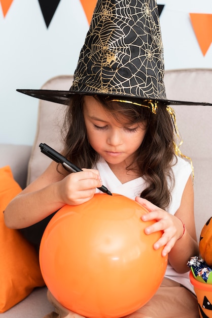 Mała dziewczynka rysuje Halloween balonu
