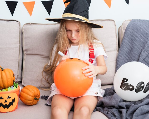 Mała dziewczynka rysuje Halloween balonu