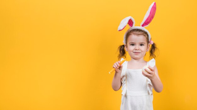 Mała dziewczynka w uszy królika z jajkiem i filcu pióra