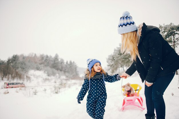Mała dziewczynka z matką bawić się w zima parku