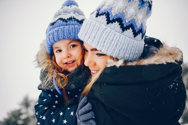 Mała dziewczynka z matką bawić się w zima parku
