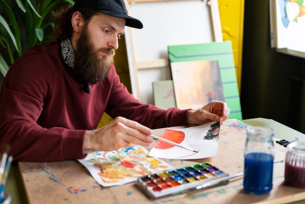 Bezpłatne zdjęcie malarz używający akwareli w swojej sztuce w studio