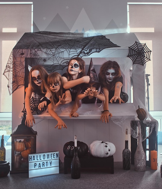 Bezpłatne zdjęcie małe domowe przyjęcie na halloween z dziećmi i nastolatkami w przerażających rolach, takich jak wampir, wiedźma, szkielet.