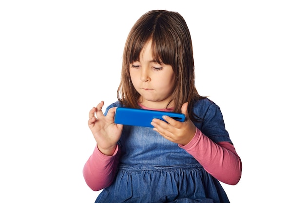 Małe dziecko, czteroletnie bawiące się telefonem komórkowym. wczesna koncepcja uzależnienia od technologii. złe nawyki