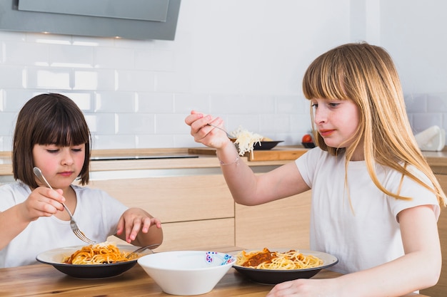 Małe dziewczynki je smakowitego spaghetti