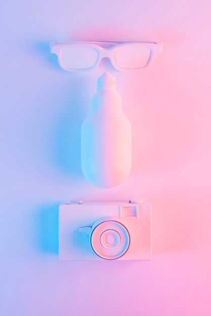 Bezpłatne zdjęcie malowane okulary przeciwsłoneczne; led żarówki i zabytkowe kamery na różowym tle