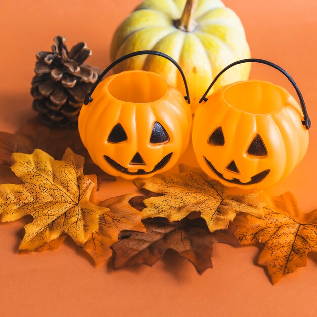 Malutkie kosze jack-o-lantern w pobliżu symboli jesieni