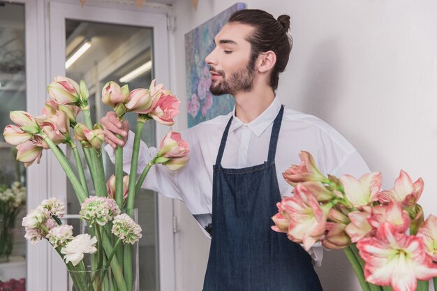 Mały biznes. Mężczyzna kwiaciarnia w kwiaciarni. wykonywanie dekoracji i aranżacji
