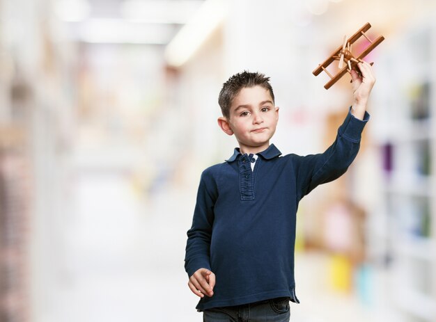 Mały chłopiec bawi się z drewnianego samolotu