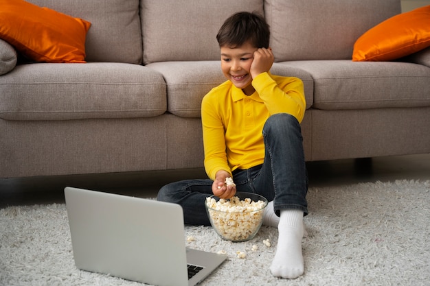 Bezpłatne zdjęcie mały chłopiec ogląda filmy na laptopie