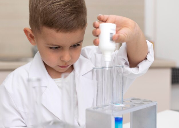 Mały chłopiec robi eksperyment naukowy w szkole