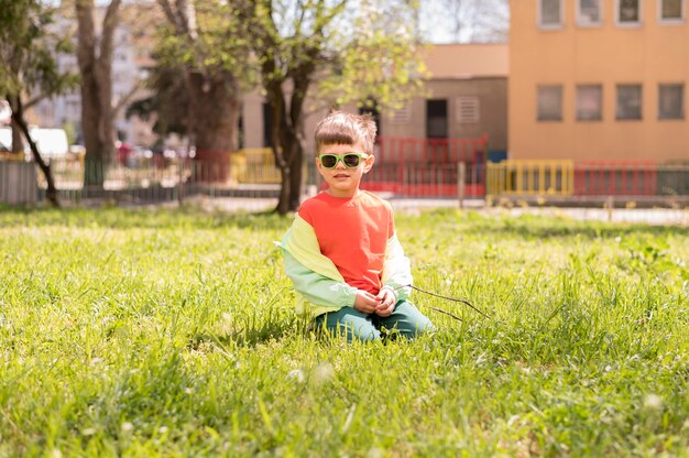 Mały chłopiec siedzi w trawie