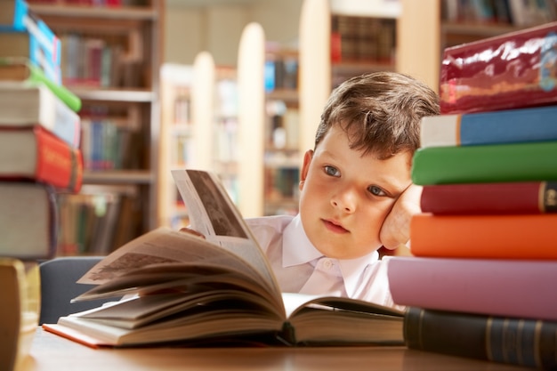 Mały chłopiec studiuje w bibliotece