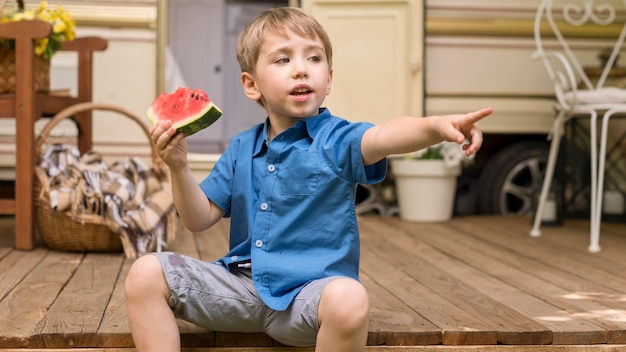 Mały chłopiec trzyma kawałek arbuza