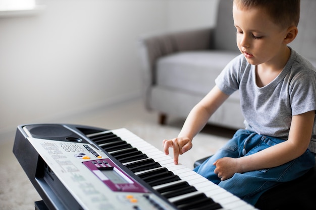 Mały chłopiec uczy się grać na pianinie