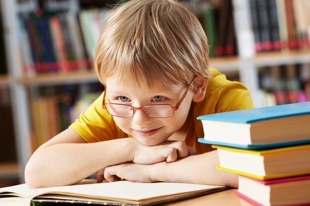 Mały chłopiec uśmiecha się do biblioteki