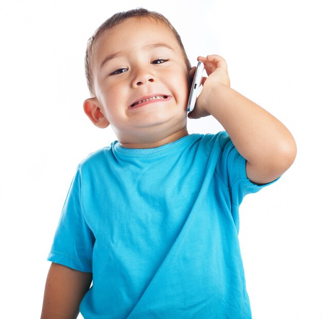 Mały chłopiec z telefonem w uchu