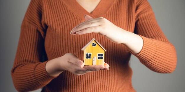 Mały Model Domu Na Ręce Kobiety życie Rodzinne I Koncepcja Nieruchomości Biznesowych Premium Zdjęcia