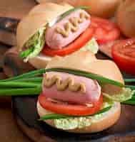 Bezpłatne zdjęcie mały wesoły hot dog z kiełbasą i pomidorem