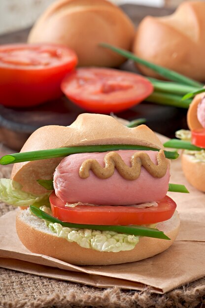 Mały wesoły hot dog z kiełbasą i pomidorem