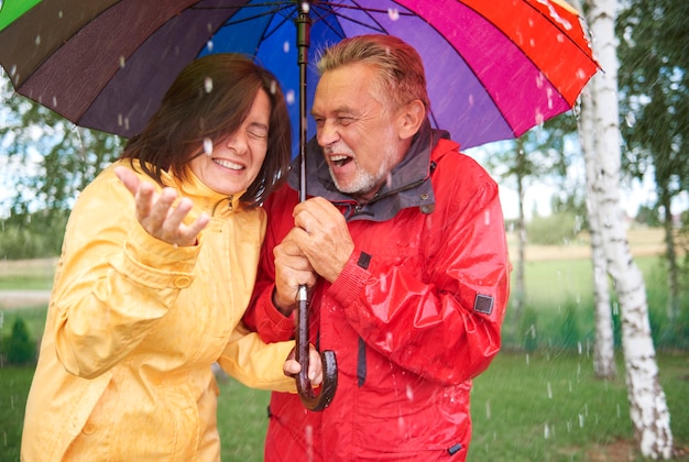 Małżeństwo trzyma kolorowy parasol