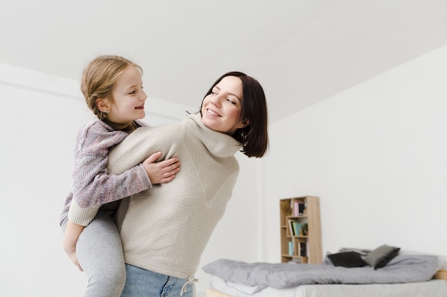 Bezpłatne zdjęcie mama daje córce przejażdżkę na barana