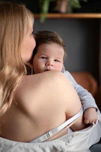 Bezpłatne zdjęcie mama delikatnie karmi dziecko piersią