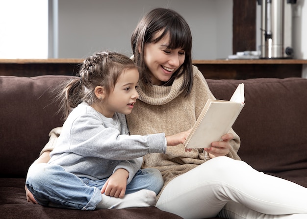 Mama i córka spędzają razem czas czytając książkę. Pojęcie rozwoju dzieci i jakości czasu.