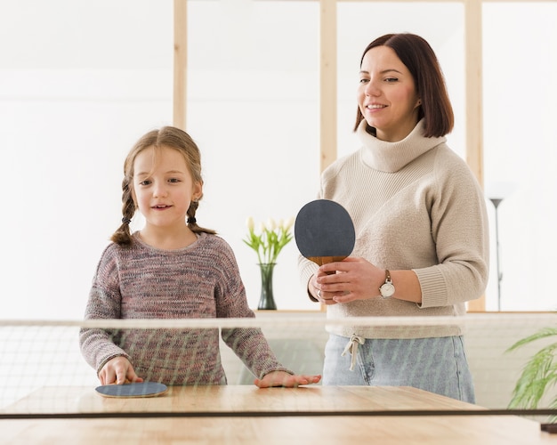 Bezpłatne zdjęcie mama i dziecko grając w tenisa stołowego