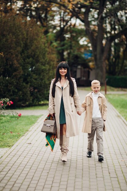 Mama i syn są w dobrych stosunkach spacerując po parku i rozmawiając Stylowy rodzinny wygląd