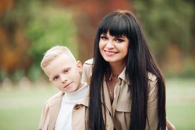 Mama i syn są w dobrych stosunkach spacerując po parku i rozmawiając Stylowy rodzinny wygląd