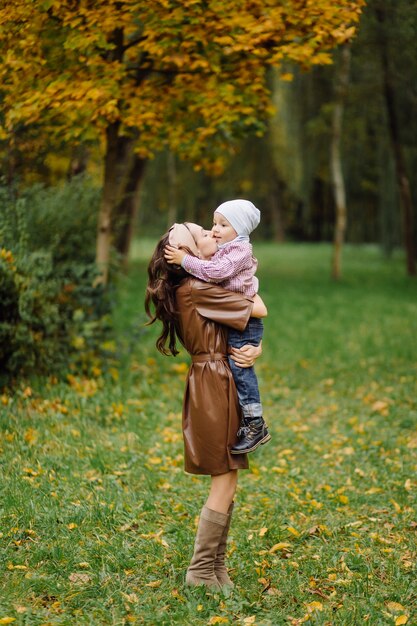 Mama i syn, spacery i zabawa w jesiennym parku.