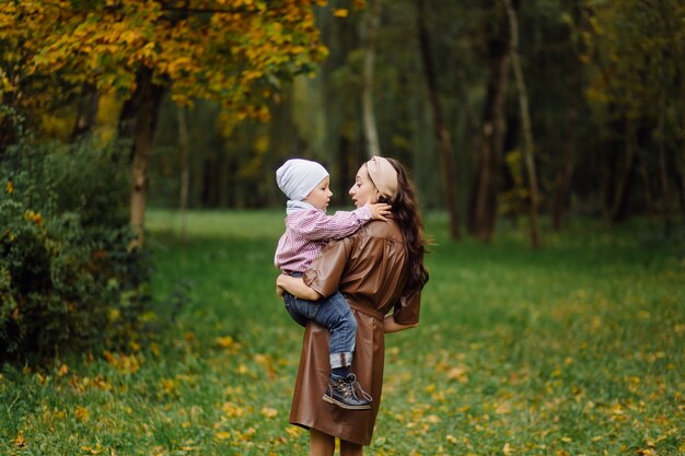 Mama i syn, spacery i zabawa w jesiennym parku.
