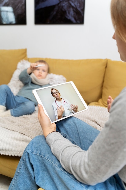 Mama opiekująca się dzieckiem i telekonsultacja z lekarzem