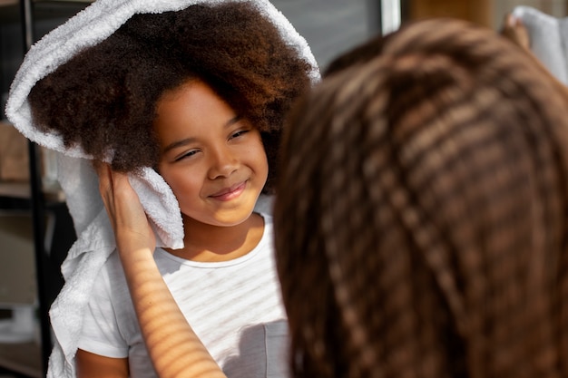 Bezpłatne zdjęcie mama pomaga dziecku w stylizacji włosów afro