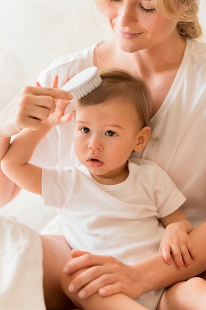 Mama w połowie strzału szczotkuje włosy dziecka