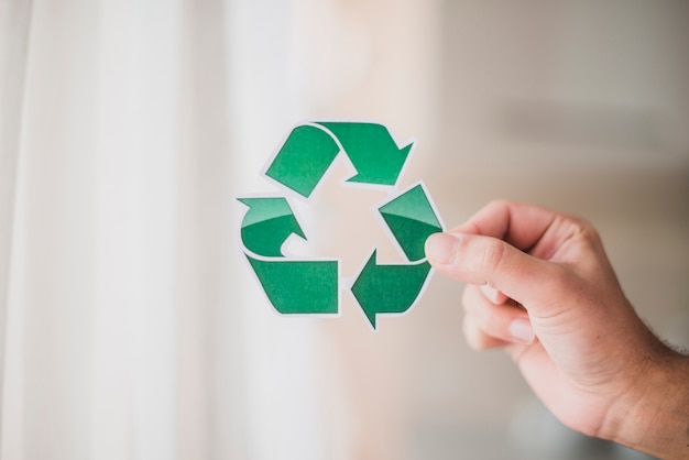 Man&#39;s hand showing recycle icon