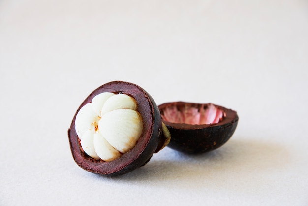 Mangostan Tajskie popularne owoce - owoce tropikalne ze słodkimi soczystymi białymi segmentami miąższu wewnątrz grubej czerwonawo-brązowej skórki.