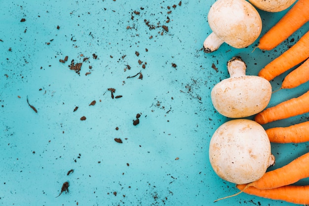 Bezpłatne zdjęcie marchew i grzyby z kosza po lewej