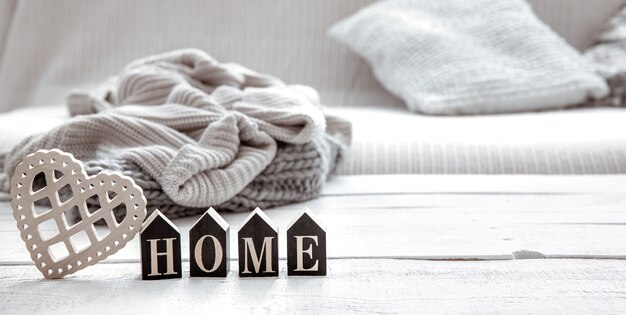 Martwa natura w stylu hygge z drewnianym słowem home i dzianiną