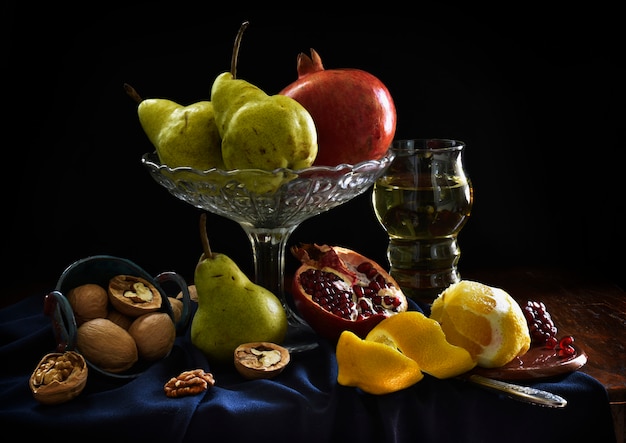 Martwa natura z granatem, cytryną, lampką wina, gruszką, orzechiem włoskim. cienie, owoce w stylu holenderskich artystów.