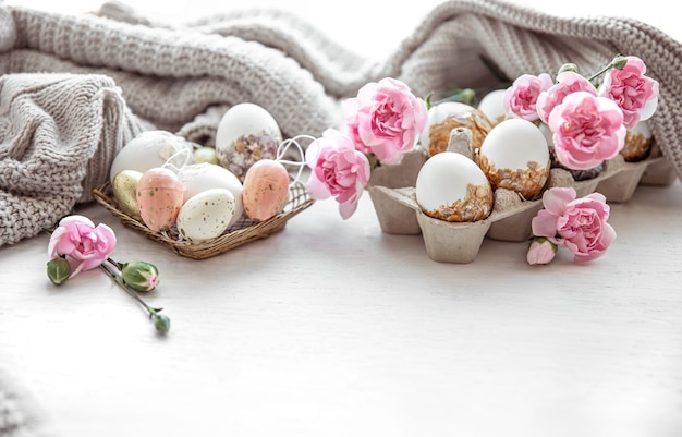 Martwa Wielkanoc z pisankami, świeżymi kwiatami i elementami dekoracyjnymi z bliska.